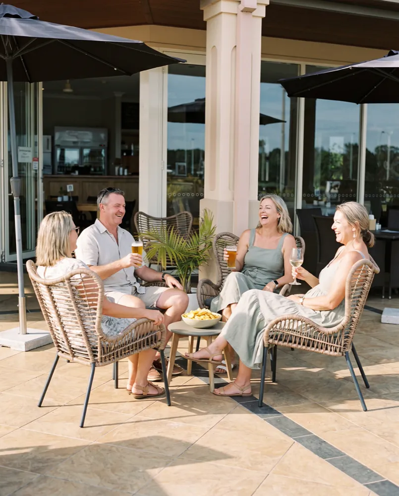Friends with beers, wine and a bowl of chips on the clubhouse deck on a sunny afternoon